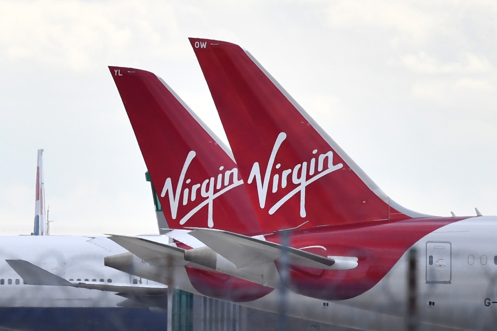 (FILES) In this file photo taken on April 02, 2020 tailfins of parked Virgin Atlantic passenger aircraft are pictured on the apron at Heathrow Airport, west of London. AFP / Ben STANSALL