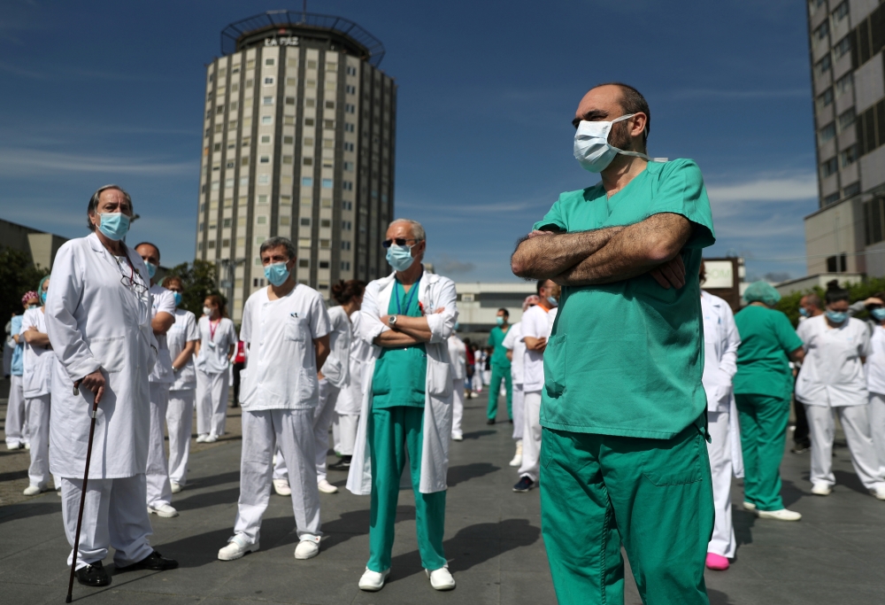 Staff from La Paz hospital take a minute of silence to remember Joaquin Diaz, the hospital's chief of surgery who died of COVID-19, amid the coronavirus disease (COVID-19) outbreak in Madrid, Spain, April 20, 2020. REUTERS/Susana Vera