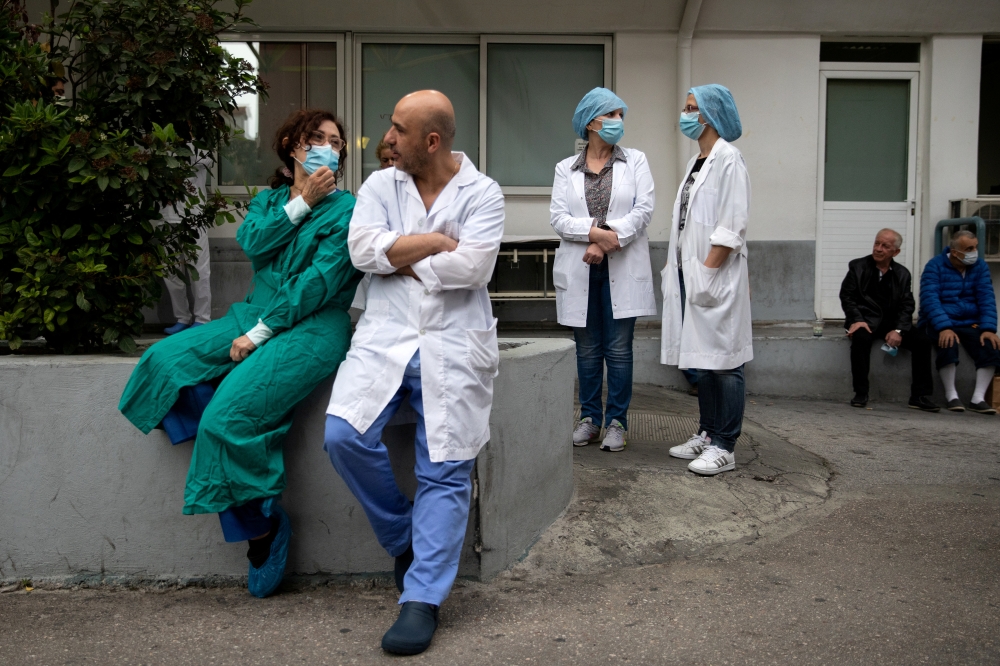 Medical workers watch a concert of the Hellenic Broadcasting Corporation (ERT) orchestra at the premises of Evangelismos hospital, following the coronavirus disease (COVID-19) outbreak in Athens, Greece, April 20, 2020. REUTERS/Alkis Konstantinidis 