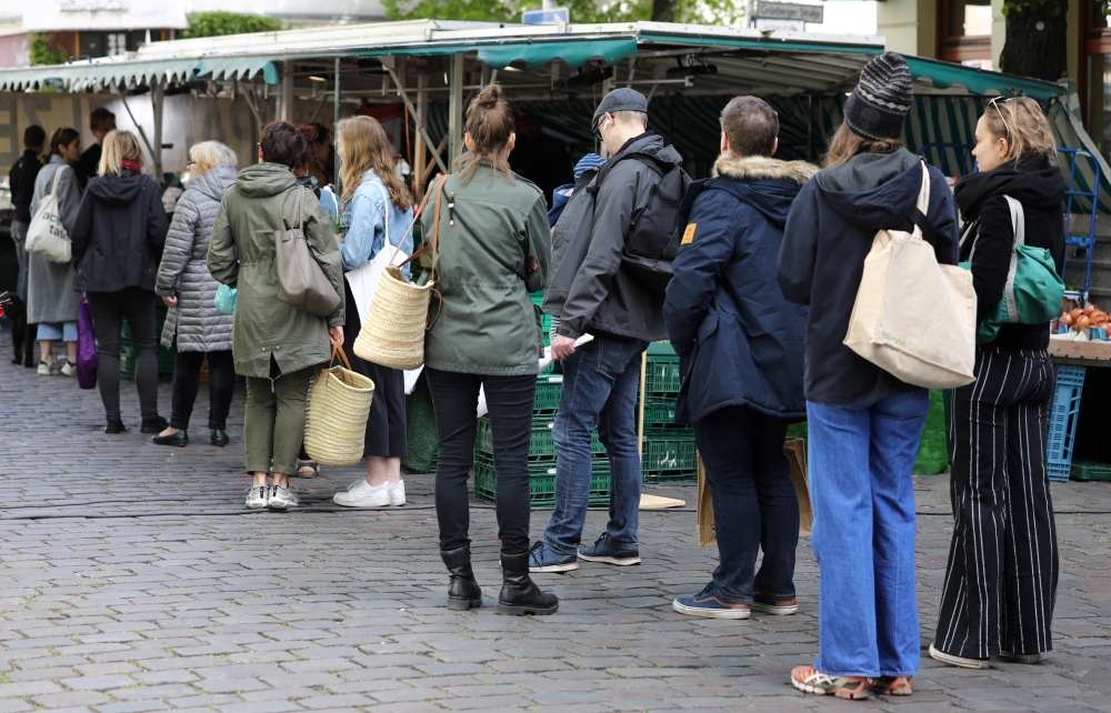 People stand in a queue at a farmers market at Boxhagener Platz, as the spread of the coronavirus disease (COVID-19) continues, in Berlin, Germany April 25, 2020. REUTERS/Christian Mang
