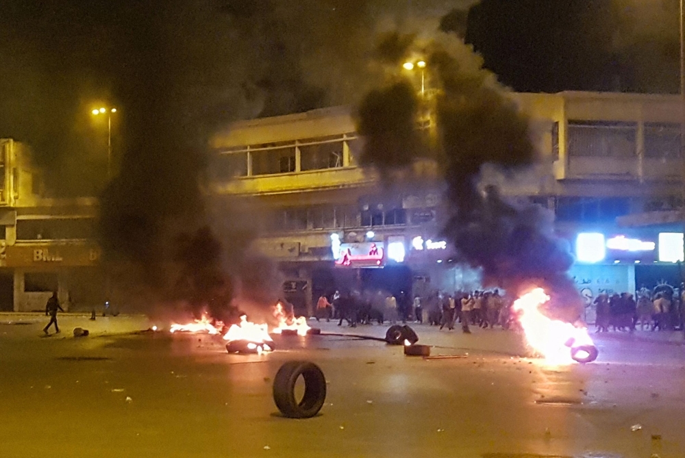 Lebanese anti-government protesters burn tyres amid clashes with security forces in the northern city of Tripoli late on April 27, 2020, following a demonstration over the country's deteriorating economy despite a coronavirus lockdown. Lebanon is facing i
