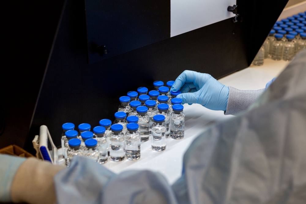 A lab technician inspects filled vials of investigational coronavirus disease (COVID-19) treatment drug remdesivir at a Gilead Sciences facility in La Verne, California, U.S. March 11, 2020. Picture taken March 11, 2020. Gilead Sciences Inc/Handout via RE