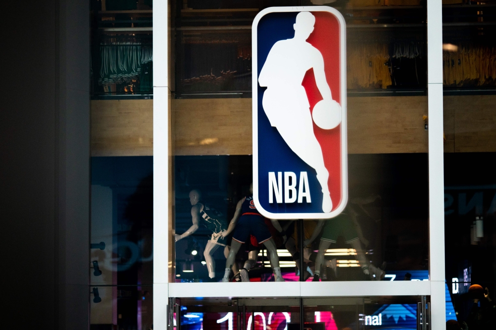 NBA logo is shown at the 5th Avenue NBA store in New York City.  AFP / Jeenah Moon