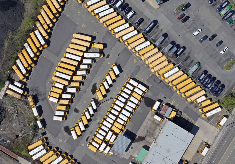 In this aerial image from a drone, unused school buses populate the First Student Bus Company parking lot on May 2, 2020 in Hicksville, New York. New York State Governor Andrew Cuomo announce yesterday that state schools will remain closed for this academ