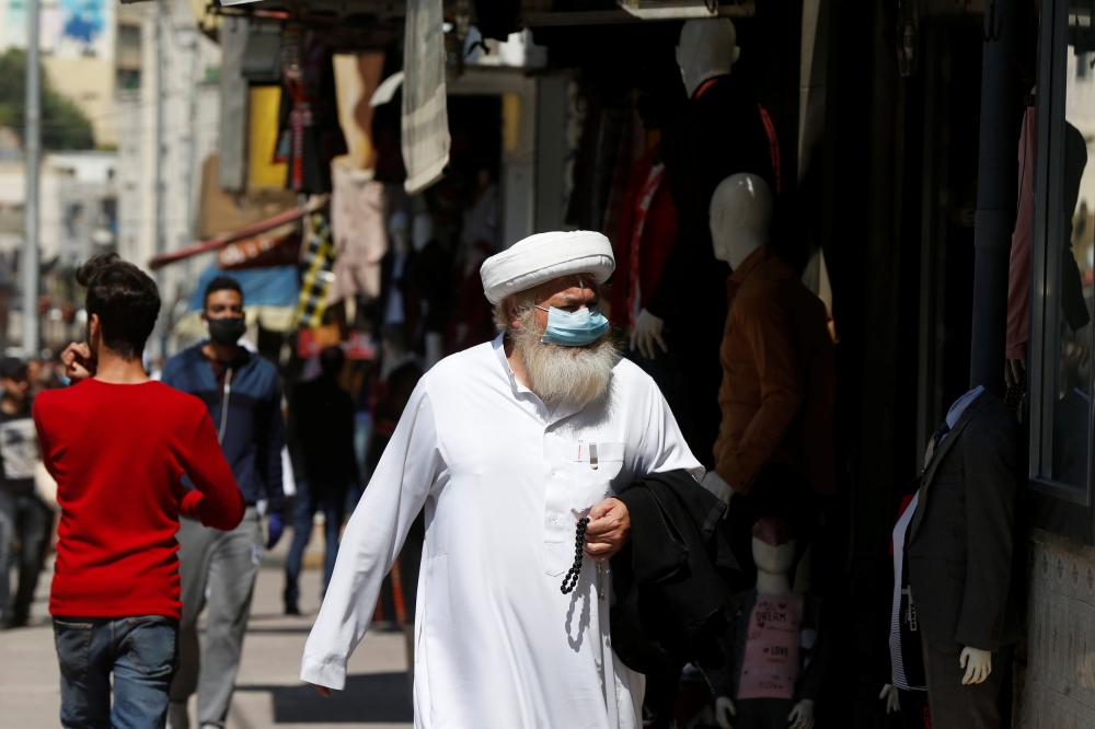 A man wears a protective face mask as he walks along the main market in downtown after the government eased the restrictions on movement aimed at containing the spread of the coronavirus disease (COVID-19), in Amman, Jordan April 29, 2020. REUTERS/Muhamma