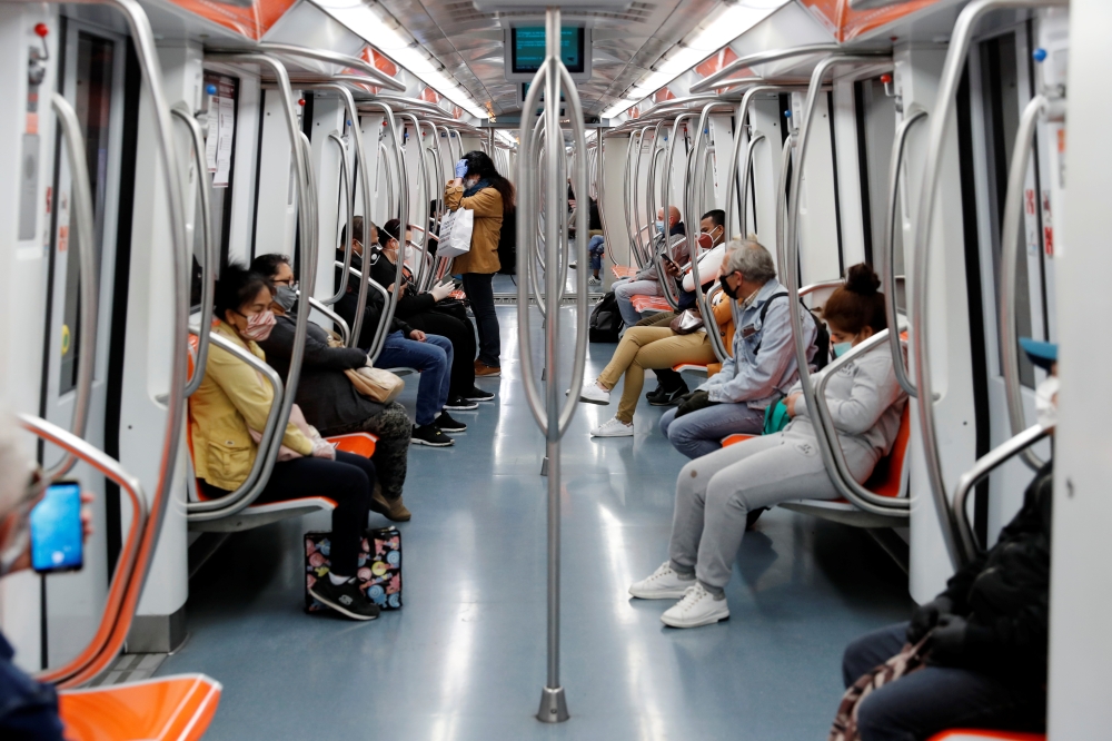 People with protective masks ride on a subway train, as Italy begins a staged end to a nationwide lockdown due to the spread of the coronavirus disease (COVID-19), in Rome, Italy May 4, 2020. REUTERS/Remo Casilli