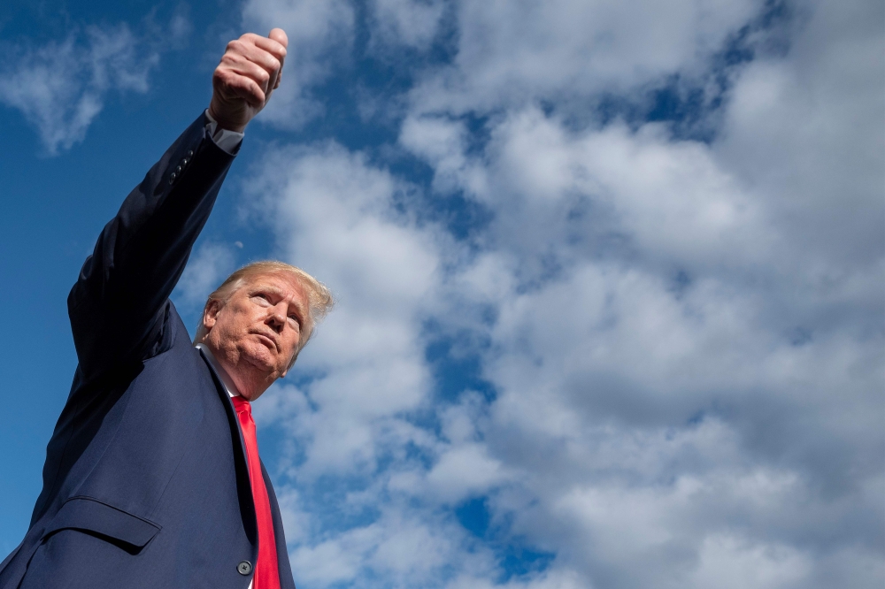 TOPSHOT - US President Donald Trump gives a thumbs up as he departs the White House, on May 1, 2020, in Washington, DC. Trump traveled to Camp David in Maryland Friday evening for weekend meetings amid the coronavirus pandemic. / AFP / JIM WATSON
