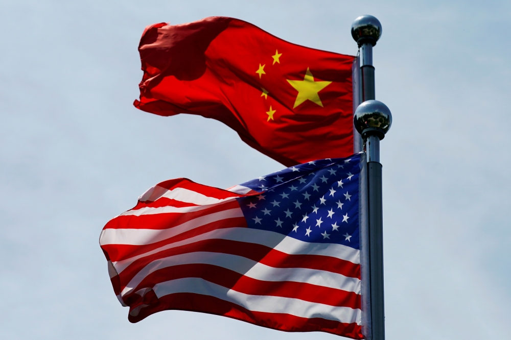 FILE PHOTO: Chinese and U.S. flags flutter near The Bund, before U.S. trade delegation meet their Chinese counterparts for talks in Shanghai, China July 30, 2019. REUTERS/Aly Song
