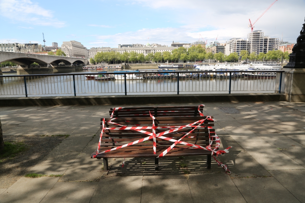 LONDON, UNITED KINGDOM - MAY 1: Benches are covered with tapes to enforce social distancing alongside the Thames River in London, England on May 1. As government prepares to announce an road map to exit strict social distancing precautions next week, toda