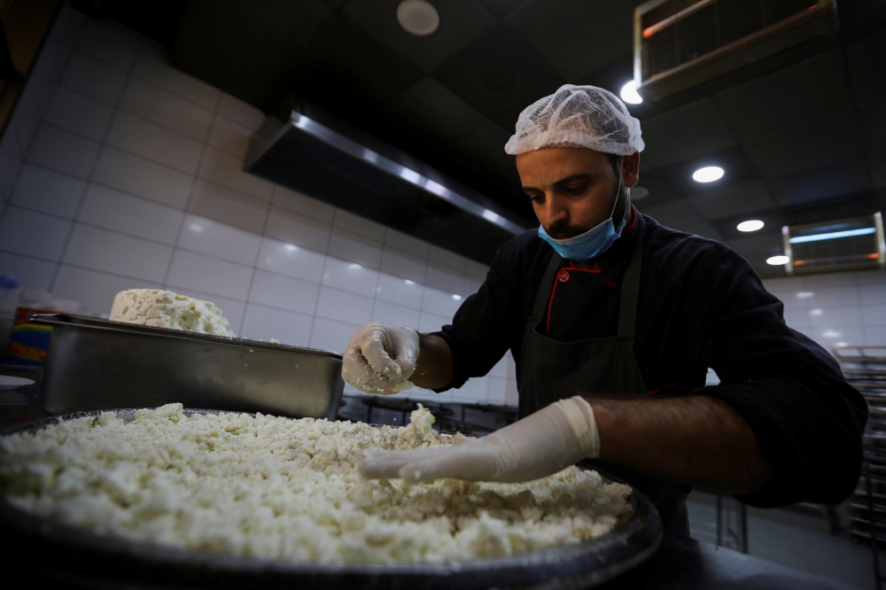 A worker prepares a traditional sweet 