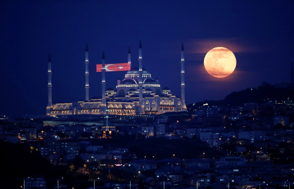 The full moon, also known as the Supermoon or Flower Moon, rises above the Camlica Mosque during the spread of the coronavirus disease (COVID-19), in Istanbul, Turkey, May 7, 2020. REUTERS/Umit Bektas