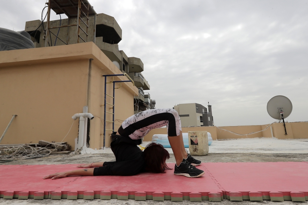 Lebanese gymnast Karen Dib practices on the rooftop of her building, during a lockdown imposed by the autorities in a bid to stem the spread of the novel coronavirus in the town of Halat, north of the capitla Beirut on April 24, 2020. AFP / JOSEPH EID

