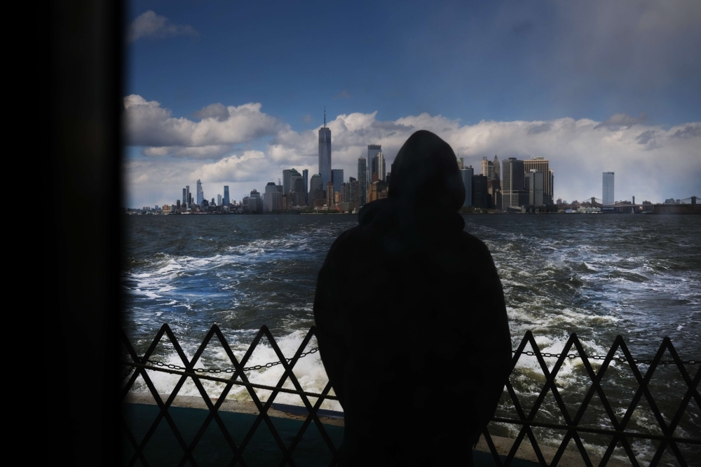 The Manhattan skyline stands in the distance as people ride the Staten Island Ferry, which commutes between Staten Island and Manhattan on May 09, 2020 in New York City. Spencer Platt/ AFP 
