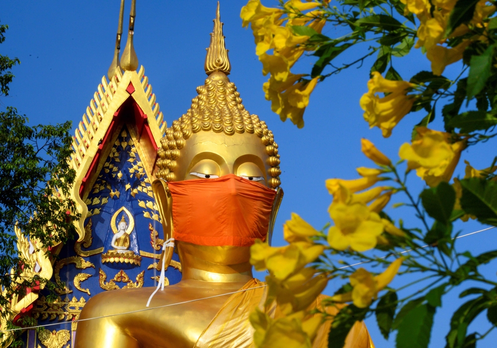 A face mask is placed on the face of a giant Buddha statue at Wat Nithet Rat Pradit temple in Pathum Thani outside Bangkok on May 12, 2020, as the country deals with the COVID-19 novel coronavirus situation.
