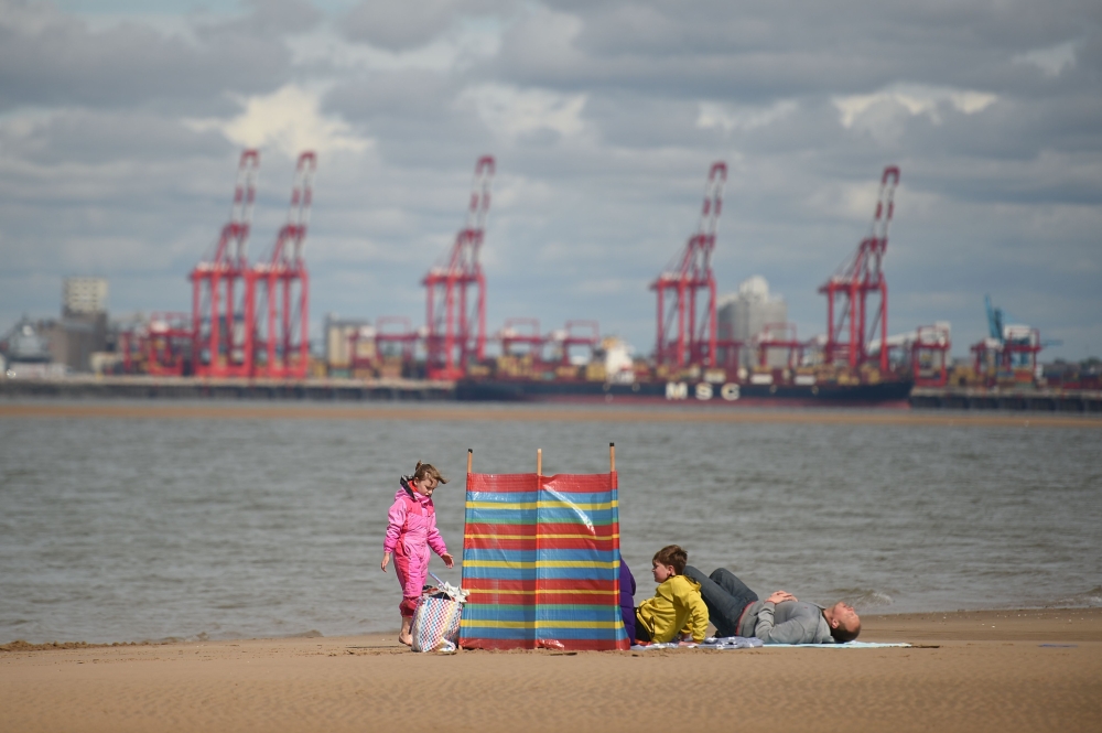 A family enjoys the sunshine on New Brighton Beach, Merseyside in north west England on May 16, 2020, following an easing of lockdown rules in England during the novel coronavirus COVID-19 pandemic. AFP / Oli Scarff 