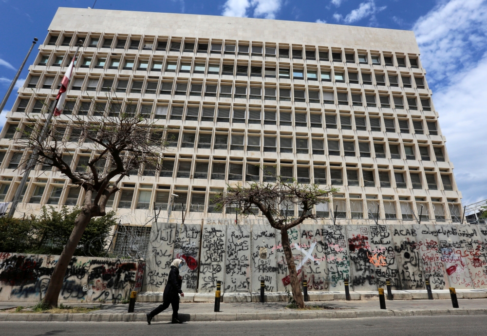FILE PHOTO: A woman wearing a protective mask walks past Central Bank building as Lebanon extends a shutdown to curb the spread of the coronavirus disease (COVID-19) in Beirut, Lebanon, May 5, 2020. REUTERS/Aziz Taher