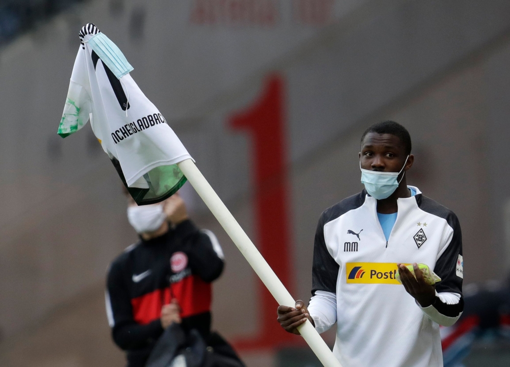 Moenchengladbach's French forward Marcus Thuram carries the corner flag after the German first division Bundesliga football match Eintracht Frankfurt v Borussia Moenchengladbach on May 16, 2020 in Frankfurt, western Germany as the season resumed following