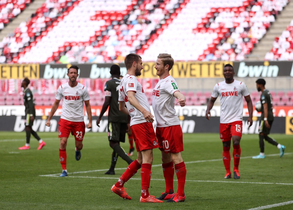 Cologne's Austrian midfielder Florian Kainz (R) celebrates scoring the 2-0 goal with his teammate Cologne's German midfielder Dominick Drexler during the German first division Bundesliga football match FC Cologne v Mainz 05 on May 17, 2020 in Cologne, wes