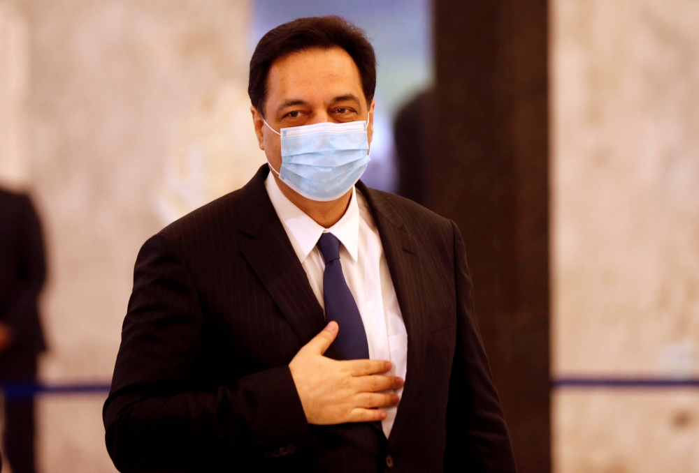 FILE PHOTO: Lebanon's Prime Minister Hassan Diab, wearing a mask, arrives to attend a meeting with Lebanese political leaders to present the plan aimed at steering the country out of a financial crisis, at the presidential palace in Baabda, Lebanon May 6,