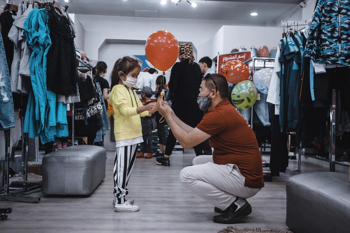 A Qatar Charity official giving Eid Al Fitr gifts to a child in Indonesia.