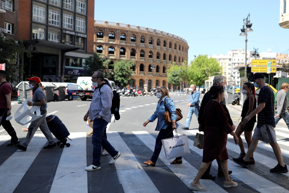 People wearing face masks walk on a crosswalk, as some Spanish provinces are allowed to ease lockdown restrictions during phase one, amid the coronavirus disease (COVID-19) outbreak, in Valencia, Spain May 19, 2020. REUTERS/Nacho Doce
