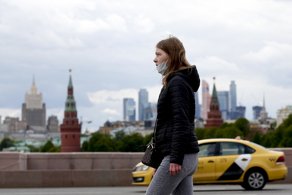 A woman wearing a mask as a precaution against coronavirus walks at a street in Moscow, Russia on May 19, 2020.  Sefa Karacan - Anadolu 
