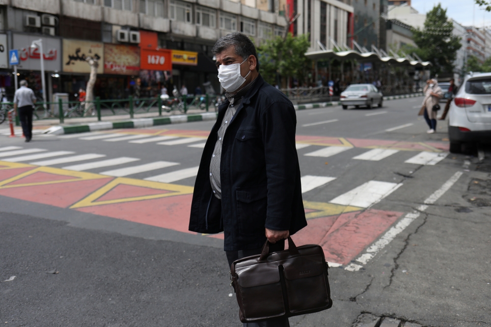An Iranian man wears a protective face mask, following the outbreak of the coronavirus disease (COVID-19), as he stands in Vali-E-Asr street, in Tehran, Iran, May 20, 2020. 