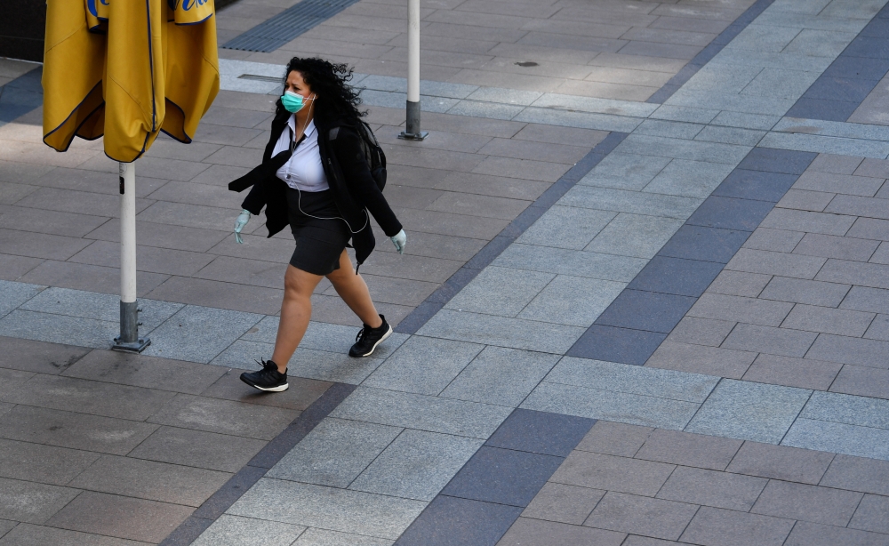 A woman wearing a protective face mask and gloves is seen in Canary Wharf, following the outbreak of the coronavirus disease (COVID-19), London, Britain, May 27, 2020. REUTERS/Dylan Martinez