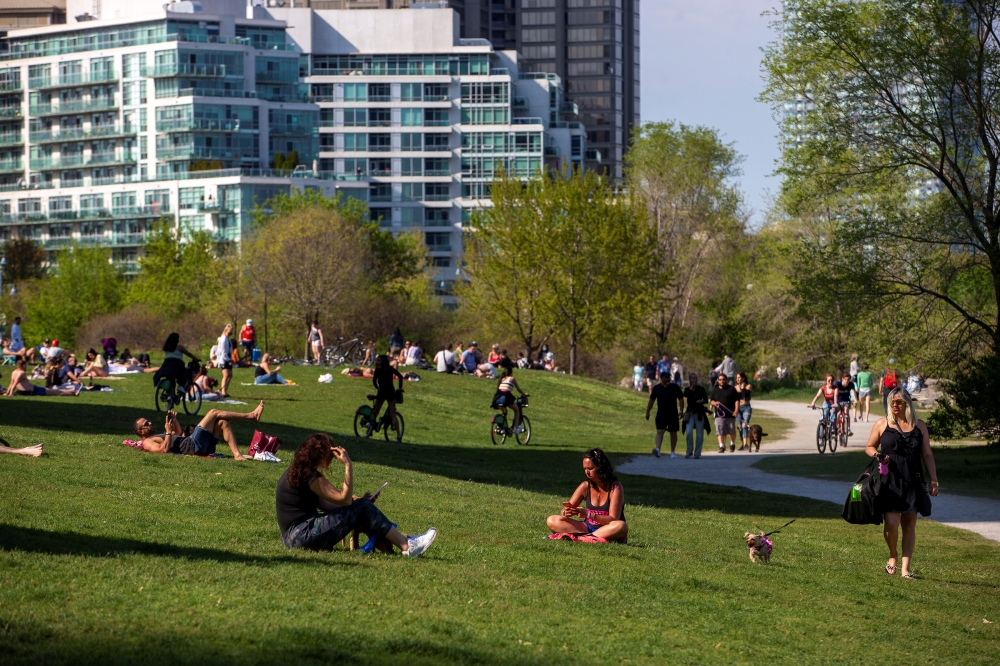 People maintain social distance as they sit at Humber Bay Shores park while the province prepares for more phased re-openings from the coronavirus disease (COVID-19) restrictions in Toronto, Ontario, Canada May 24, 2020. REUTERS/Carlos Osorio
