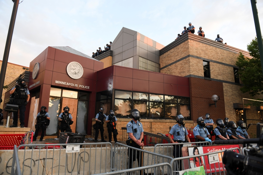 Police officers monitor protests at the Minneapolis Police third precinct after a white police officer was caught on a bystander's video pressing his knee into the neck of African-American man George Floyd, who later died at a hospital, in Minneapolis, Mi