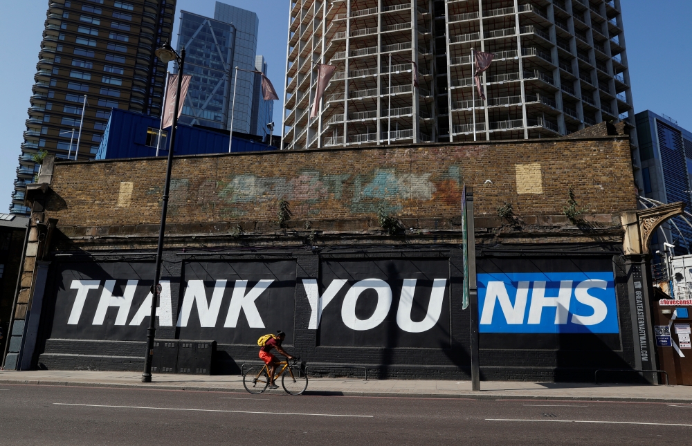 A cyclist rides past a thank you message in NHS in Shoreditch, following the outbreak of the coronavirus disease (COVID-19), London, Britain, May 30, 2020. REUTERS/John Sibley