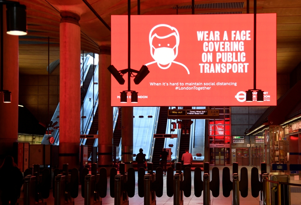 Public health messages are seen during morning rush hour at Canary Wharf underground station, following the outbreak of the coronavirus disease (COVID-19), London, Britain, June 1, 2020. REUTERS/Toby Melville
