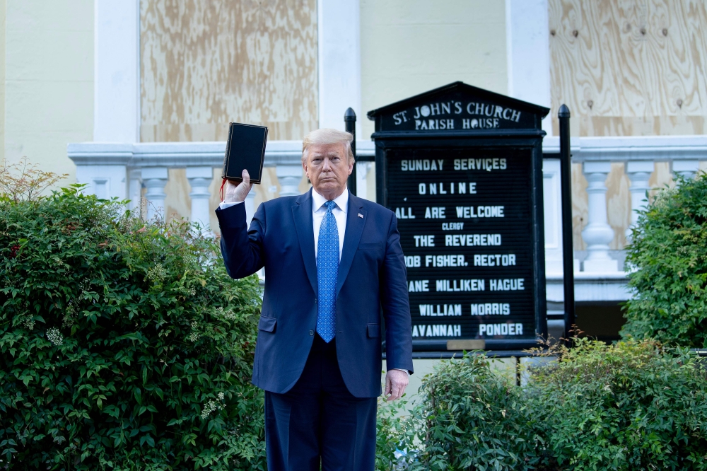 US President Donald Trump holds a Bible while visiting St. John's Church across from the White House after the area was cleared of people protesting the death of George Floyd June 1, 2020, in Washington, DC. AFP / Brendan Smialowski