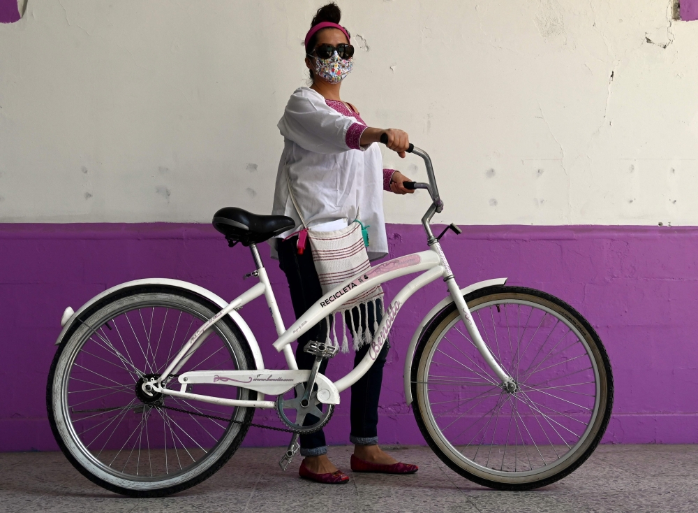 Mexican doctor Yolanda Perez poses after receiving a bicycle from the Biciteka Foundation in Mexico City on May 24, 2020. amid the new coronavirus pandemic. AFP / Rodrigo Arangua 