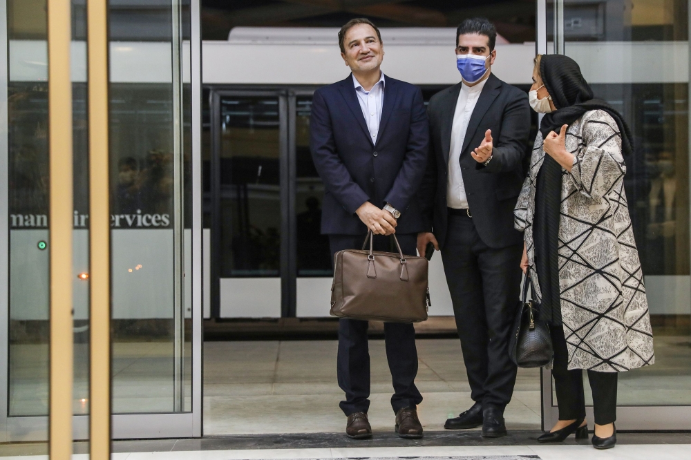 Iranian doctor Majid Taheri (L), who had been detained in the United States for 16 months, is welcomed by his wife and an Iranian Foreign Ministry official upon his arrival at Tehran's Imam Khomeini International Airport on June 8, 2020. AFP / MEHR NEWS /