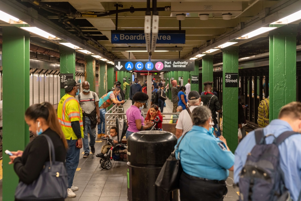 NEW YORK, NY - JUNE 08: People wait for the train at Times Square during rush hour on the first day of phase one of the reopening after the coronavirus lockdown on June 8, 2020 in New York City. New York City enters phase one one hundred days after the fi