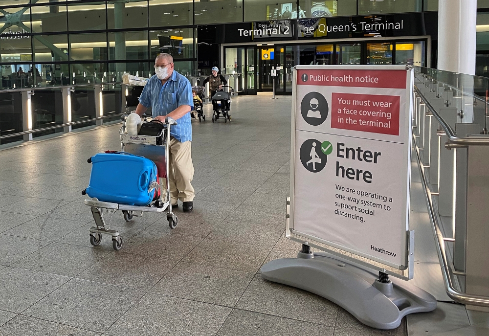 A passenger walks through a terminal at Heathrow Airport, as Britain launches its 14-day quarantine for international arrivals, following the outbreak of the coronavirus disease (COVID-19), London, Britain, June 8, 2020. REUTERS/Toby Melville
