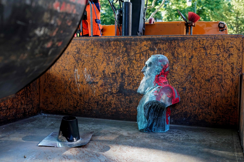 A bust of Belgium former king Leopold II that has been daubed with red paint is removed by a city worker in Auderghem, near Brussels on June 12, 2020 as several statues of the late monarch, a symbol of Belgium's bloody history as colonial power in central