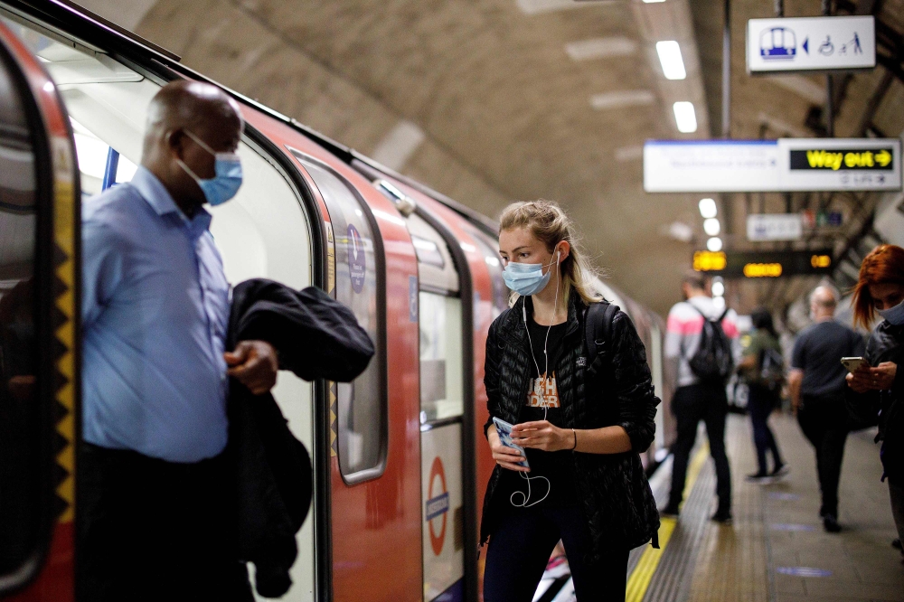 Commuters wearing a face mask travel on TfL Victoria Line underground train carriages, heading towards central London, on June 15, 2020 after new rules make wearing face coverings on public transport compulsory while the UK further eases its coronavirus l