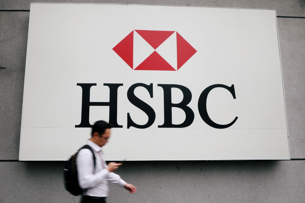 A man walks past a logo of HSBC at its headquarters in Kuala Lumpur, Malaysia August 6, 2019. REUTERS/Lim Huey Teng/File Photo