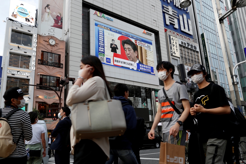 A large screen on a building shows live broadcast of Japan's Prime Minister Shinzo Abe's news conference in Tokyo, Japan May 25, 2020. REUTERS/Issei Kato/File Photo