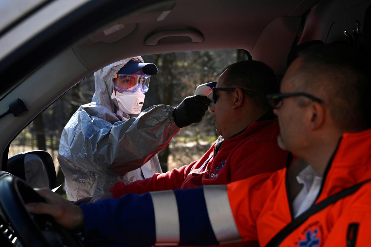 FILE PHOTO: A police officer in a protective suit checks the temperature of a person inside a car at Slovak-Czech border in Drietoma crossing, Slovakia, March 13, 2020. REUTERS/Radovan Stoklasa

