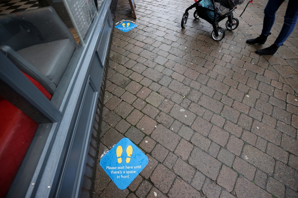 Social distancing markings are seen outside a Greggs bakery shop, as it reopens following the outbreak of the coronavirus disease (COVID-19), in Newcastle-under-Lyme, Staffordshire, Britain June 18, 2020. REUTERS/Carl Recine