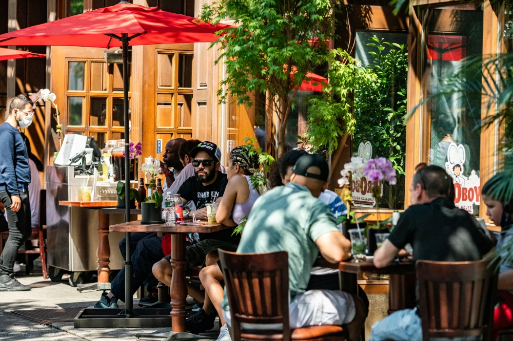 People eat in outdoor seating outside a restaurant before the city starts phase two of reopening after the lockdown due to the coronavirus disease (COVID-19), in the Manhattan borough of New York City, U.S., June 21, 2020. REUTERS/Jeenah Moon
