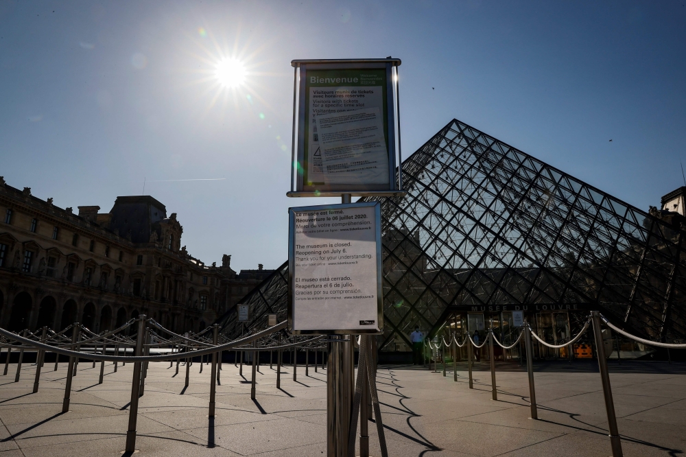 A picture taken on June 23, 2020 shows the Louvre pyramid by Chinese architect Ieoh Ming Pei, and the Louvre Museum in Paris.  / AFP / THOMAS SAMSON
