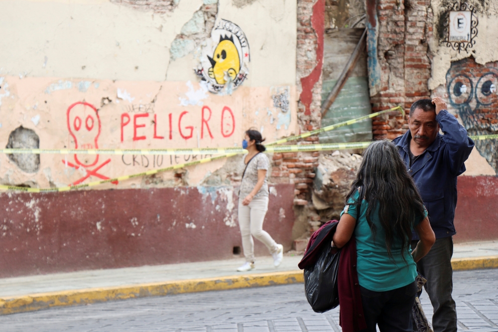 People talk near a building damaged during a quake, in Oaxaca, Mexico June 24, 2020. REUTERS/Jorge Luis Plata/File Photo
 
