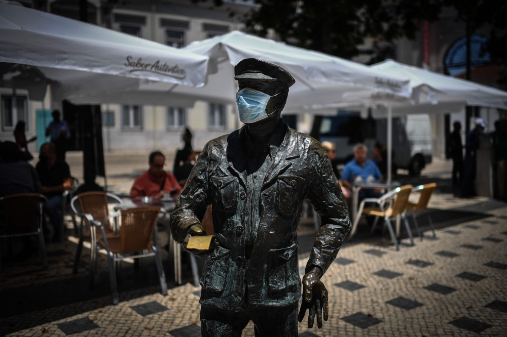 A statue wearing a face mask is pictured in downtown Lisbon on June 23, 2020. Portugal's Prime Minister Antonio Costa said on June 22, 2020 that some coronavirus restrictions would be reimposed in the capital Lisbon to help control outbreaks from the pand