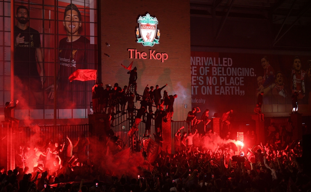 Fans celebrate Liverpool winning the Premier League title outside Anfield stadium in Liverpool, north west England on June 25, 2020, following Chelsea's 2-1 victory over Manchester City. AFP / Oli SCARFF