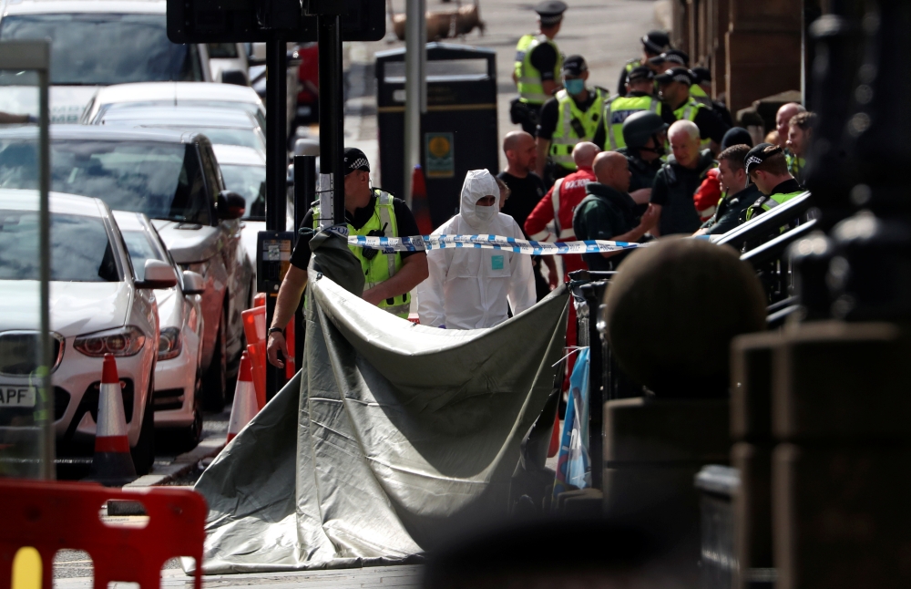 A forensic officer works at the scene of reported multiple stabbings at West George Street in Glasgow, Scotland, Britain June 26, 2020. REUTERS/Russell Cheyne
