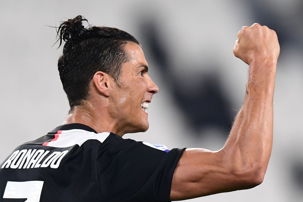Juventus' Portuguese forward Cristiano Ronaldo celebrates after scoring a penalty during the Italian Serie A football match Juventus vs Lecce played on June 26, 2020 behind closed doors at the Juventus stadium in Turin. AFP / Miguel MEDINA
